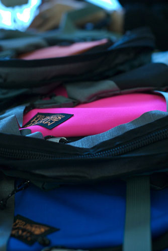 Colorful backpacks stacked with zippers partially open