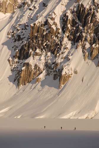 Hikers trekking across snow-covered mountain landscape