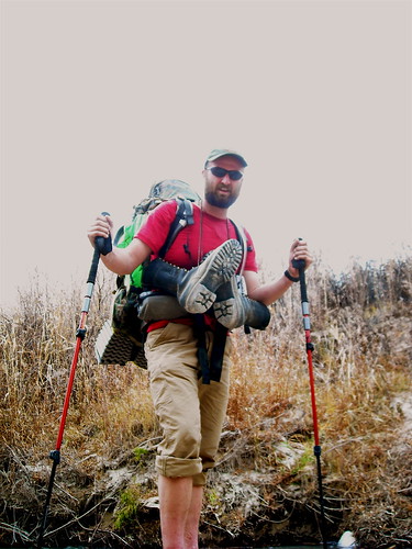 Hiker with backpack and trekking poles outdoors
