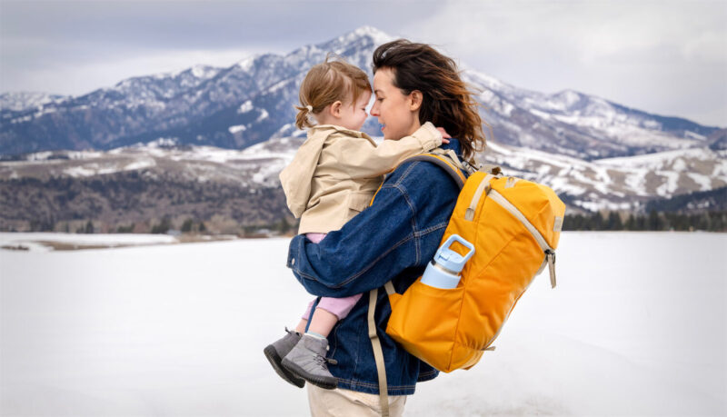 Woman with Backpack holding a young girl