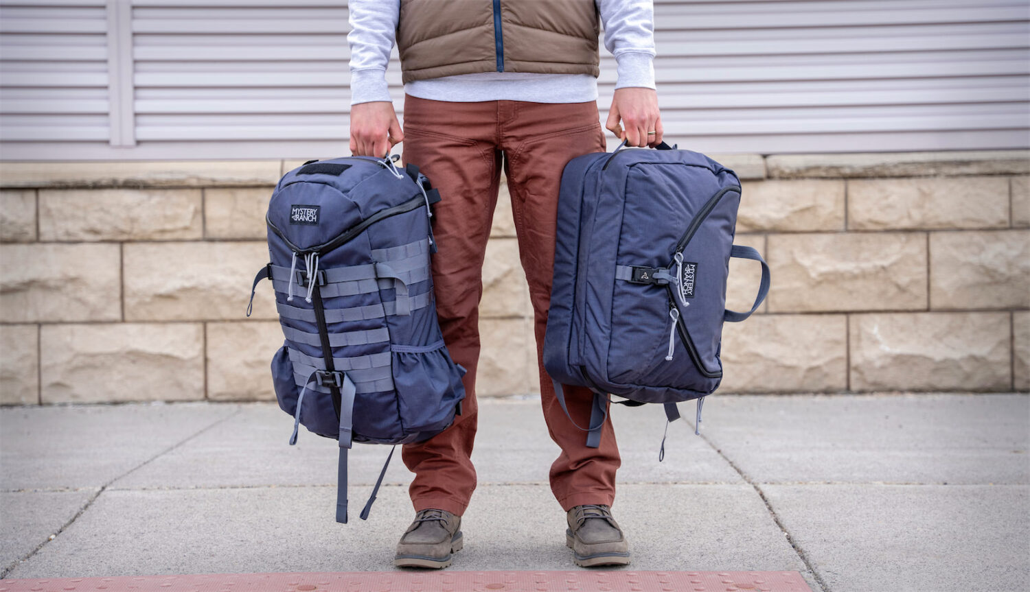 Person holding MYSTERY RANCH 2 DAY ASSAULT and 3 WAY BRIEFCASE 27